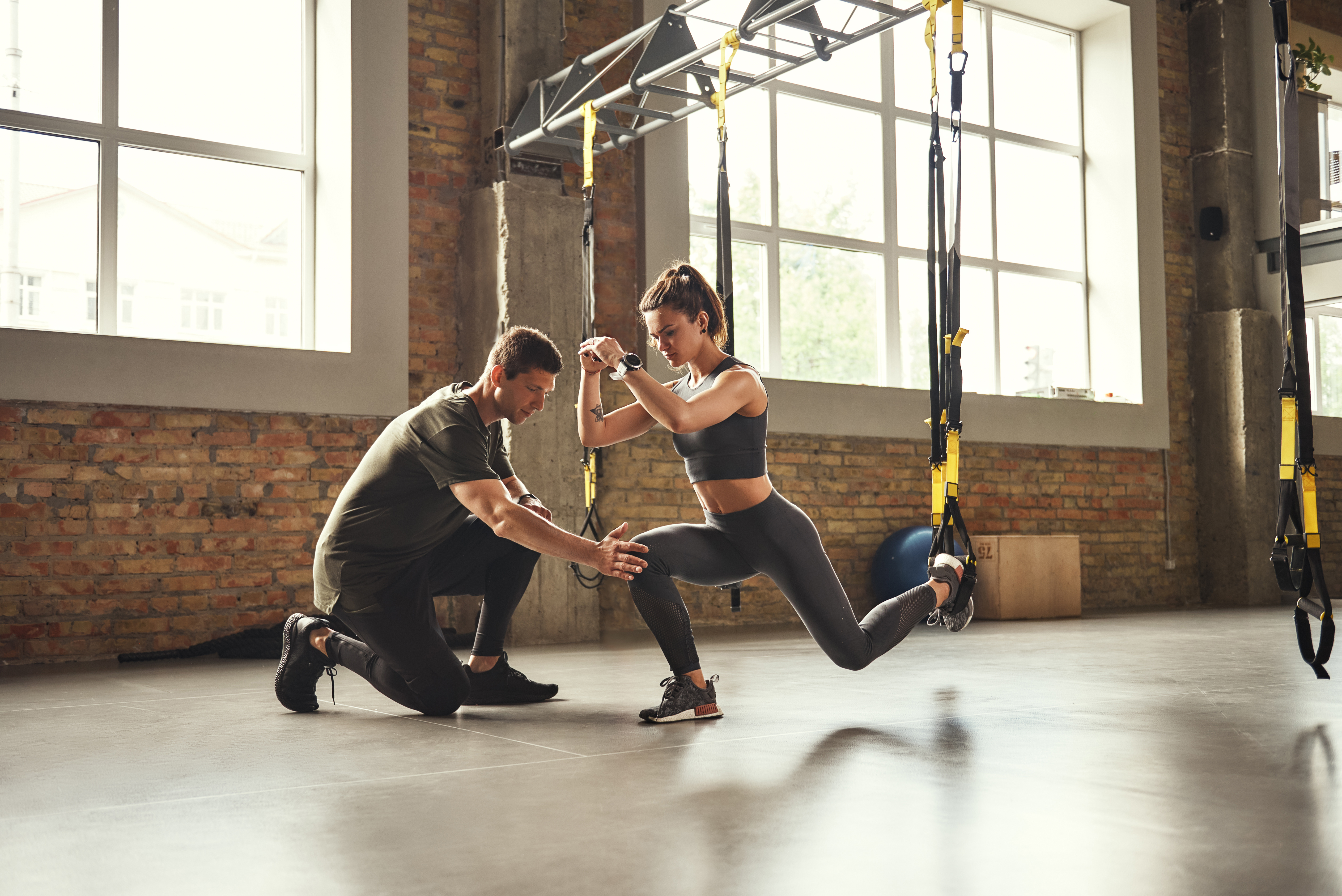 Personaltrainer im Fitnessstudio mit Kundin