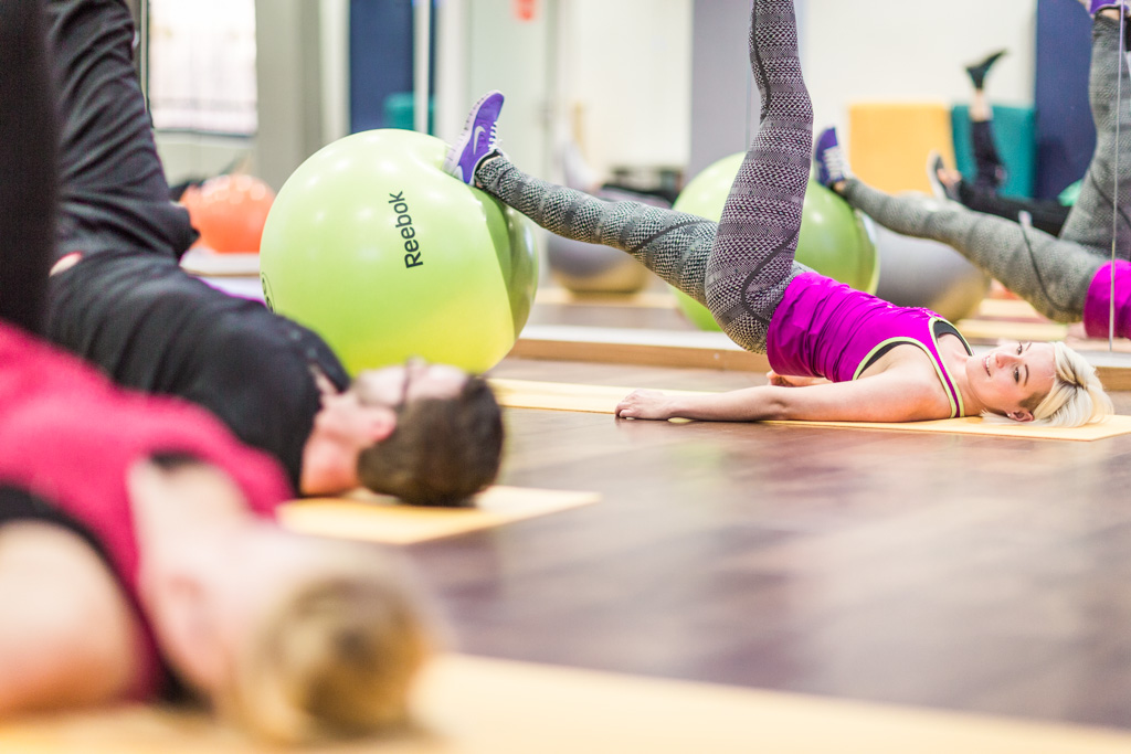 Frauen und Männer beim Pilates Kurs