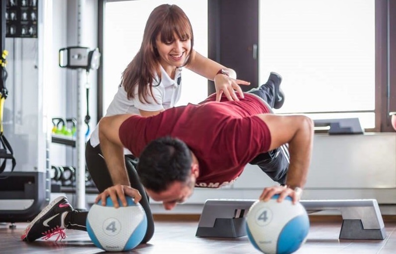 Personaltrainerin bei einer Liegestützübung