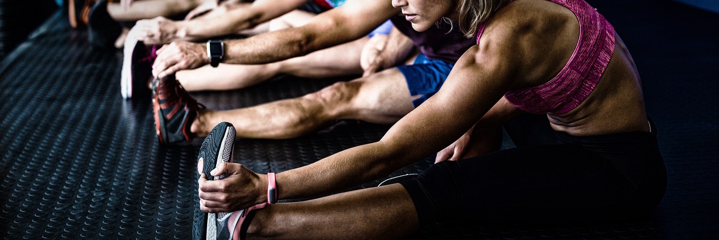 Sportler beim Dehnen im Fitnessstudio